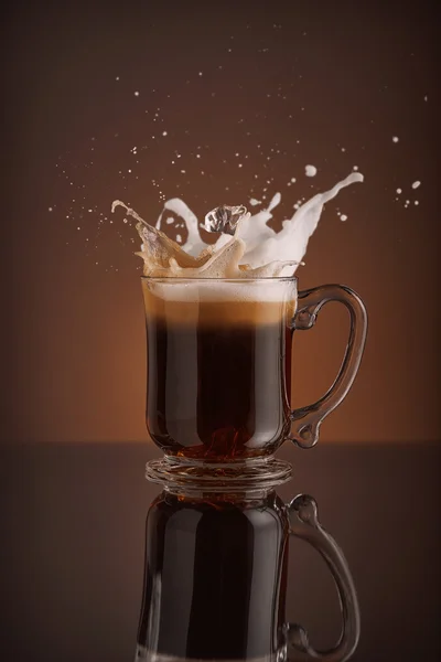 Splash van ijs koffie geïsoleerd op bruine achtergrond — Stockfoto