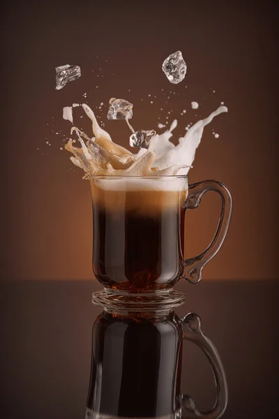 Splash of ice coffee isolated on brown background — Stock Photo, Image