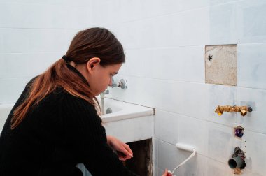 Banyo seramik duvar kiremitlerini boyayan genç kadın, kendin yap, yenileme. ,