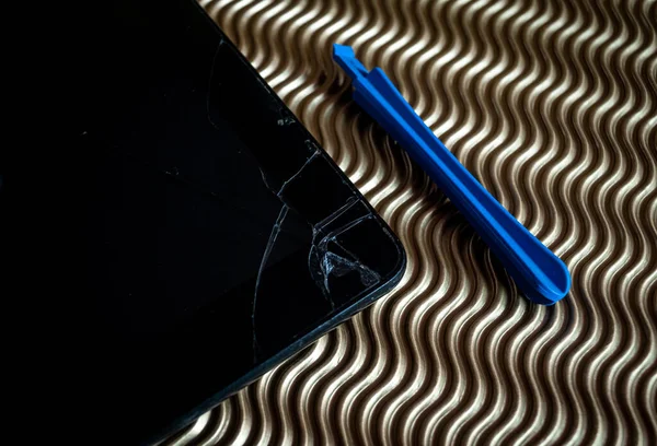 Broken tablet with smashed screen and tool to repair . on graphic background.