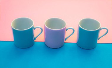 Renkli arka planda pembe ve mavi kahve fincanları, parlak renklerde grafik resim.