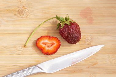 Bir kesme tahtası üzerinde yalnız çilek