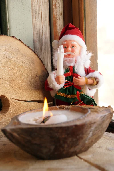 Santa Claus and a candle in a coconut — Stock Photo, Image