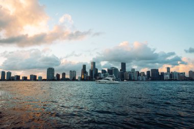 Biscayne Körfezi 'nin karşısındaki Miami Skyline manzarası. Gün batımında fırtına bulutları var.