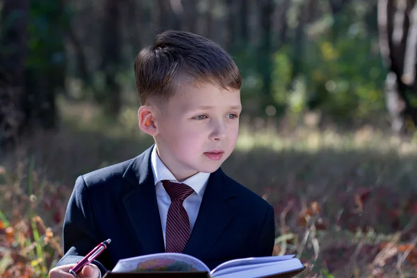 Niño pequeño en un traje de negocios inspirado mira a un lado — Foto de Stock