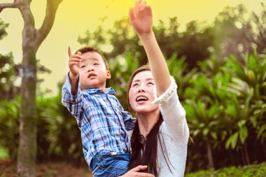 Gökyüzüne dönük ve aralarında en küçük oğlu tutan genç anne