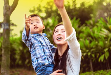 Gökyüzüne dönük ve aralarında en küçük oğlu tutan genç anne