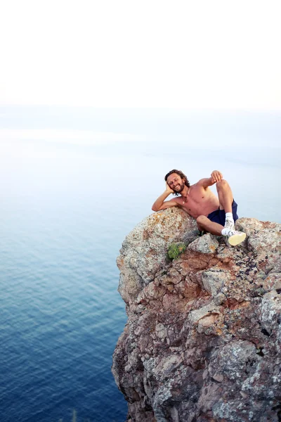 Człowiek znajduje się na szczycie góry i odpoczynku — Zdjęcie stockowe