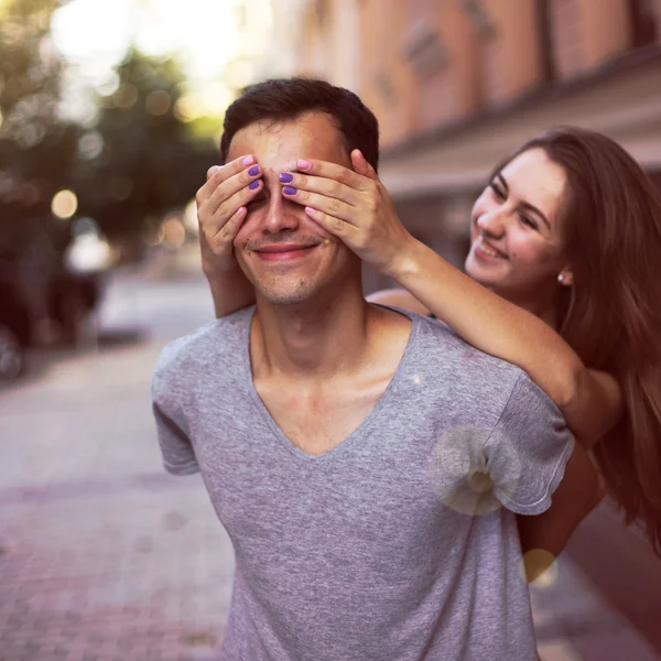 Ela fecha os olhos para um cara fazendo sua surpresa sorrindo — Fotografia de Stock