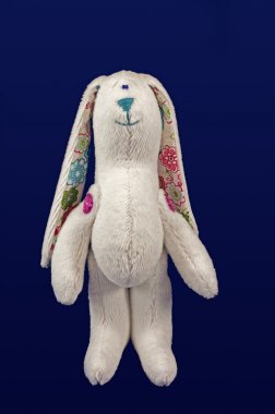 stuffed soft funny white hare isolated over blue background clipart