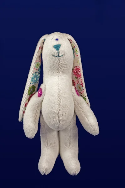 毛绒软有趣小白兔孤立在蓝色的背景 — 图库照片