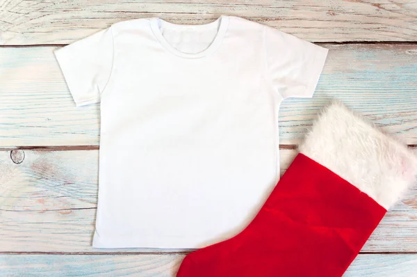 Noel çocuğu tişörtü maketi. Ahşap arka planda beyaz tişört. Stok fotoğrafı.
