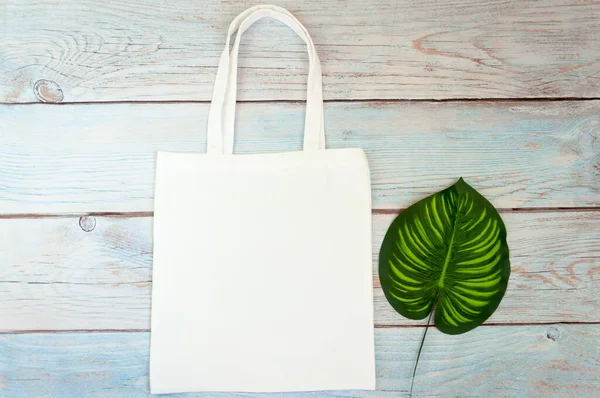 Tote bag canvas fabric cloth shopping sack mockup blank template on wooden background. Stock photo.