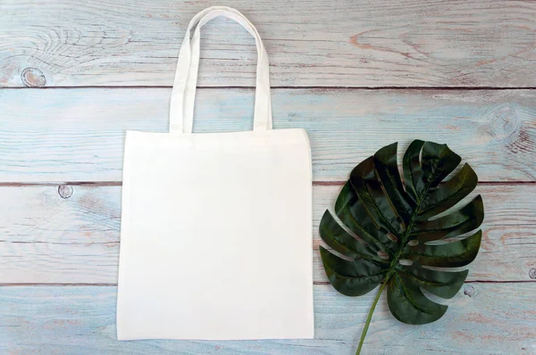 Tote bag canvas fabric cloth shopping sack mockup blank template on wooden background. Stock photo.