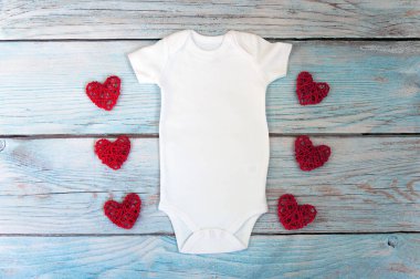 Noel beyazı bebek kıyafetleri ahşap arka planda. Moda stok fotoğrafçılığı. Model.