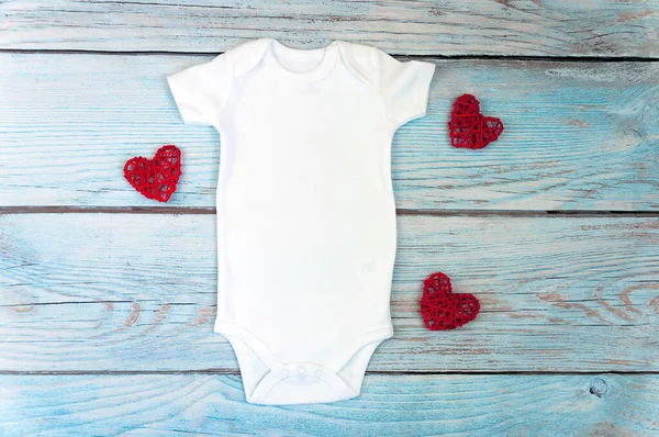 Noel beyazı bebek kıyafetleri ahşap arka planda. Moda stok fotoğrafçılığı. Model