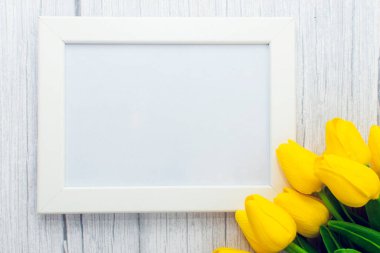 Ahşap arka planda sarı lale çiçekleri süslenmiş resim çerçevesi modeli. Biçimli stok fotoğrafçılığı.