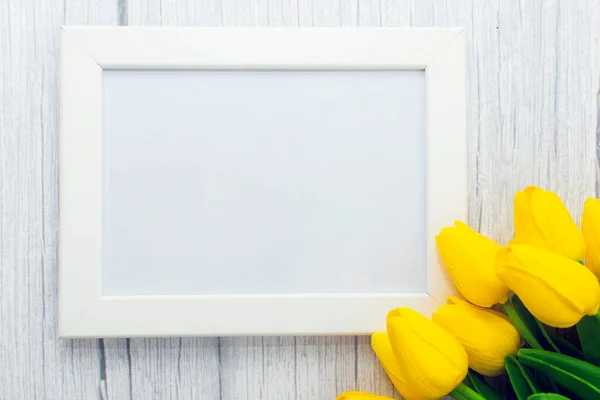 Ahşap arka planda sarı lale çiçekleri süslenmiş resim çerçevesi modeli. Biçimli stok fotoğrafçılığı.