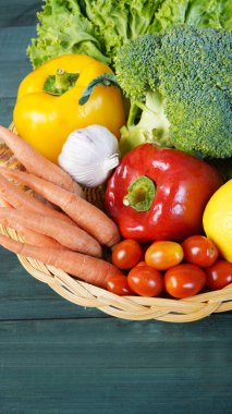 Tahta masa manzaralı sepetin içinde taze organik sebzeler. Sağlıklı gıda konsepti.