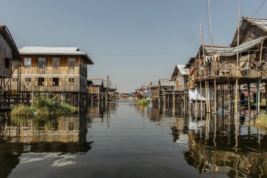 Inle Gölü 'nün yüzen köyü Myanmar' ın en görkemli yerleri ve özelliklerinden biridir. Asya 'da kırsal yaşam tarzı. Balıkçılar basit evler. Teknedeki insanlar. Geleneksel bambu binaları