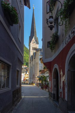 Hallstatt, Avusturya-Ağustos 10.2020. Ünlü güzel Avusturya dağ kasabası Hallstat. Arka planda boş kaldırım taşı caddesi ve kilise manzarası. Şehir manzarası. Avrupa 'da seyahat.