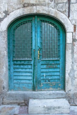 Güzel, mavi, boyanmış bir kapı. Tuğla duvardaki mavi grunge ahşap kapı. Karadağ ve Avrupa 'da eski kırsal ahşap kapılar.
