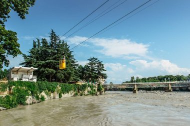 Rioni nehri kenarındaki Ropeway İstasyonu, Kutaisi. Kutaisi 'nin yukarısındaki tepede eski sarı teleferikle yükselebilirsin. Turistlerin ilgisini çek. Şehir manzarasının tadını çıkar ve eğlen..