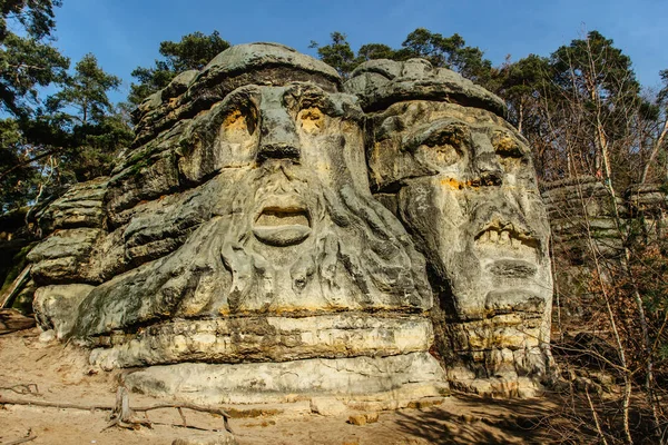 Two giant heads of devils carved into sandstone rocks,each is about 9m high.Devils Heads created by Vaclav Levy near Libechov, Czech republic.Cliff carvings carved in pine forest.Tourist attraction