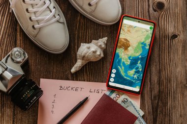 Travel concept banner flat lay.Items for summer vacation: passport,sneakers,money,smartphone with Asia map,retro camera copy space.Top view vacation concept.Planning fun trip.Travel accessories clipart