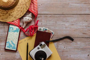 Seyahat konsepti pankartı düz taban. Yaz tatili için eşyalar: pasaport, bikini, şapka, para, Avrupa haritalı akıllı telefon, kamera kopyası alanı. Üst görünüm tatil kavramı. Deniz yoluyla eğlenceli bir gezi planlama.