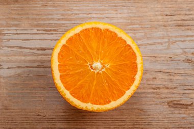 Taze toplanmış meyvelerin en üst görüntüsü. Tahta masada tatlı, sulu, yarım portakal dilimi. Sağlıklı beslenme vitamini C.Summer tropikal meyve konsepti düz katman. Olgun organik sitrus. Portakal dilimi izole edilmiş.