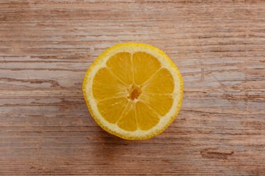 Taze toplanmış meyvelerin en üst görüntüsü. Tahta masada tatlı, sulu, yarım dilimlenmiş limon. Sağlıklı beslenme vitamini C.Summer tropikal meyve konsepti düz katman. Olgun organik sitrus. Limon dilimi izole edilmiş.