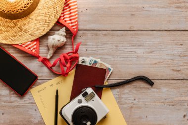 Seyahat konsepti pankartı düzlüğü. Yaz tatili için eşyalar: pasaport, bikini, şapka, para, akıllı telefon, kamera fotokopi alanı. En iyi tatil konsepti. Deniz yoluyla eğlenceli bir gezi planlama. Dünyayı keşfetmek için aksesuarlar.