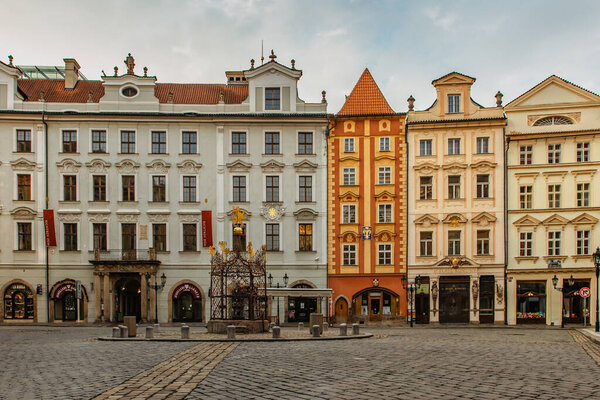 Prague,Czech Republic - March 26,2021. Empty cute and tiny Little Square with colorful medieval houses close to Old Town Square.Fountain is situated in the middle,The Rott House with decorative facade