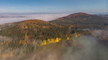 Idyllic hilly foggy landscape.Natural autumn scenic countryside.Beautiful view of misty morning scenery and forested rocky hills called Velky,Great, and Maly,Small, Blanik,Czech republic. clipart