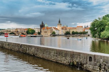 Prag, Çek Cumhuriyeti-4 Ağustos 2021. Pedallı teknelerle Vltava Nehri 'ni geçen ve eğlenen turistler, arka planda Charles Köprüsü. Nehir gezisi, turistik gezi, şık bir şehir manzarası..