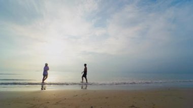 4K VDO silueti Asyalı çift yazın yapılan balayı aktivitesinden mutluluk ve neşe içinde kucaklaşıp el ele tutuşuyorlar