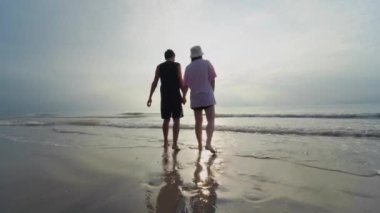 4K vdo siluet Asyalı çift yazın balayı aktivitesinden mutlu ve mutlu bir şekilde el ele tutuşuyorlar.