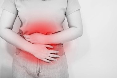 Beyaz, izole edilmiş portre karın ağrısı ve 30-40 yaş arası, tek renkli ve kırmızı noktalı bir kadının acı hissi.