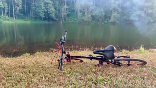 Vdo自転車は湖を背景に芝生の上に置きます — ストック動画