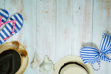 Web afişi ve düz bir yaz mevsimi mayolu ve plaj aksesuarlı klasik mavi ahşap arka planda.
