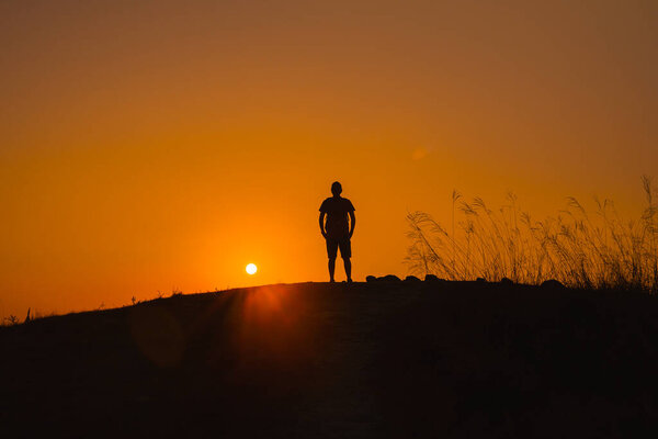 adventure travel from silhouette man hiking and stand on top of the mountain in summer season