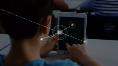Okulda ders sırasında dijital tablet kullanan okul çocuğu üzerinden bağlantı ağının animasyonu. Küresel bilim öğrenme eğitim kavramı dijital olarak oluşturulmuş görüntü.