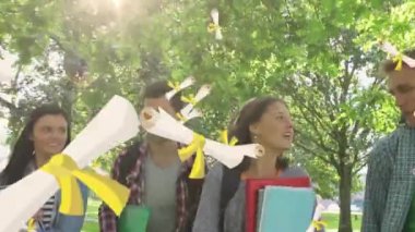 Parkta yürüyen ve konuşan öğrencilerin üzerine düşen diploma belgelerinin animasyonu. Mezuniyet öğrenme konsepti dijital olarak oluşturulmuş imaj.