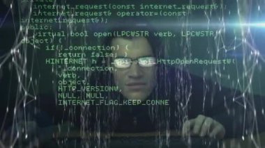 Kafkasyalı bir erkek hacker kapüşonlu ve güneş gözlüklü bilgisayar kullanırken beyaz ağ ile bağlanan yeşil bilgisayar verilerinin animasyonu. Dijital bileşik video