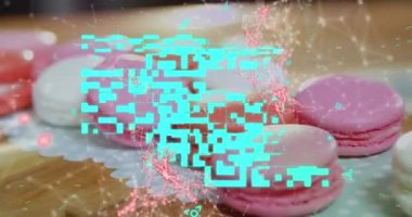 Masada duran pembe macaronilerin üzerinde kırmızı yüzen bağlantı ağı olan mavi bir QR kodunun animasyonu. Dijital bileşik video