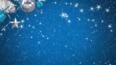 Noel süslerinin dijital animasyonu ve yıldız süslemeleri mavi arka planda düşen yıldızlara karşı Noel ağacında asılı..