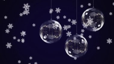 Mavi arka planda asılı duran değerli süslemelerin üzerine düşen kar tanelerinin dijital animasyonu. Noel kutlaması geleneği