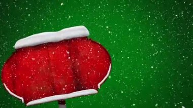 Yeşil arka planda kırmızı tahta levha direğinin üzerine düşen karın dijital animasyonu. Noel kutlaması geleneği