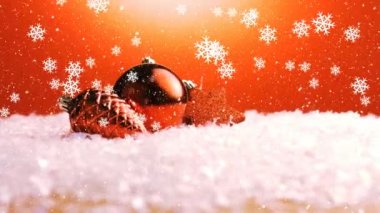 Kırmızı Noel süslerinin animasyonu, kırmızı zemine yağan kar. Noel kutlaması konsepti dijital olarak oluşturulmuş görüntü.